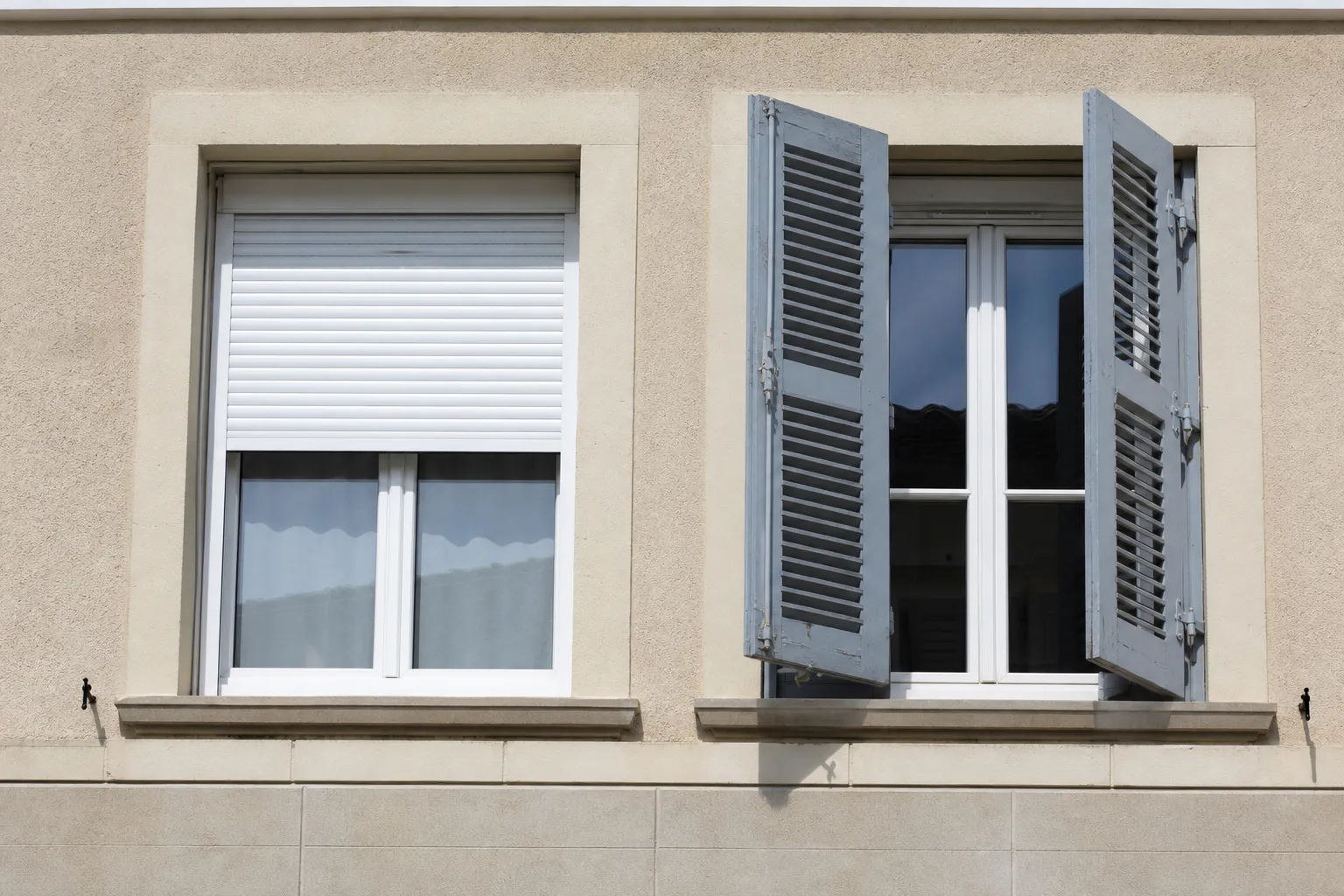 Façade avec une fenêtre équipée d’un volet roulant et une fenêtre équipée d’un volet battant