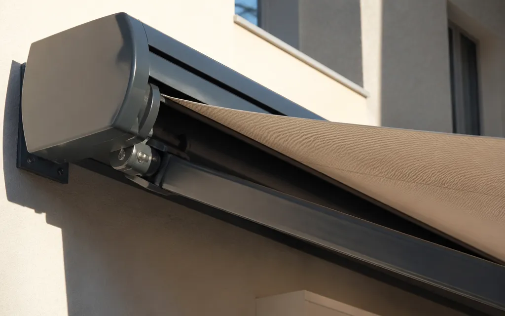 Bras articulé et coffre de store banne vus de près, mécanisme visible