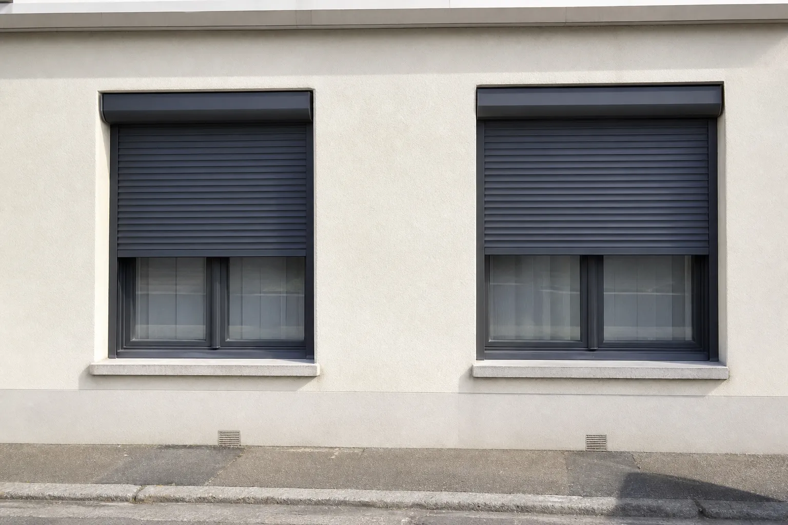 Coffre et lames de volet roulant en aluminium posés sur une façade résidentielle